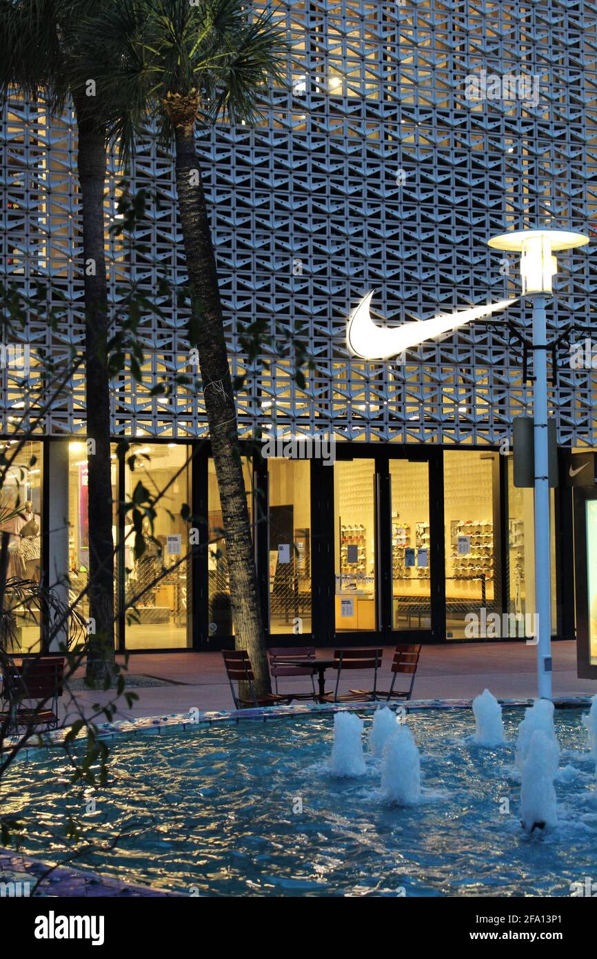 NIKE Store exterior during sunrise in Lincoln Road Mall in Miami Beach, Florida. Front of store with water fountain and palm trees. Stock Photo