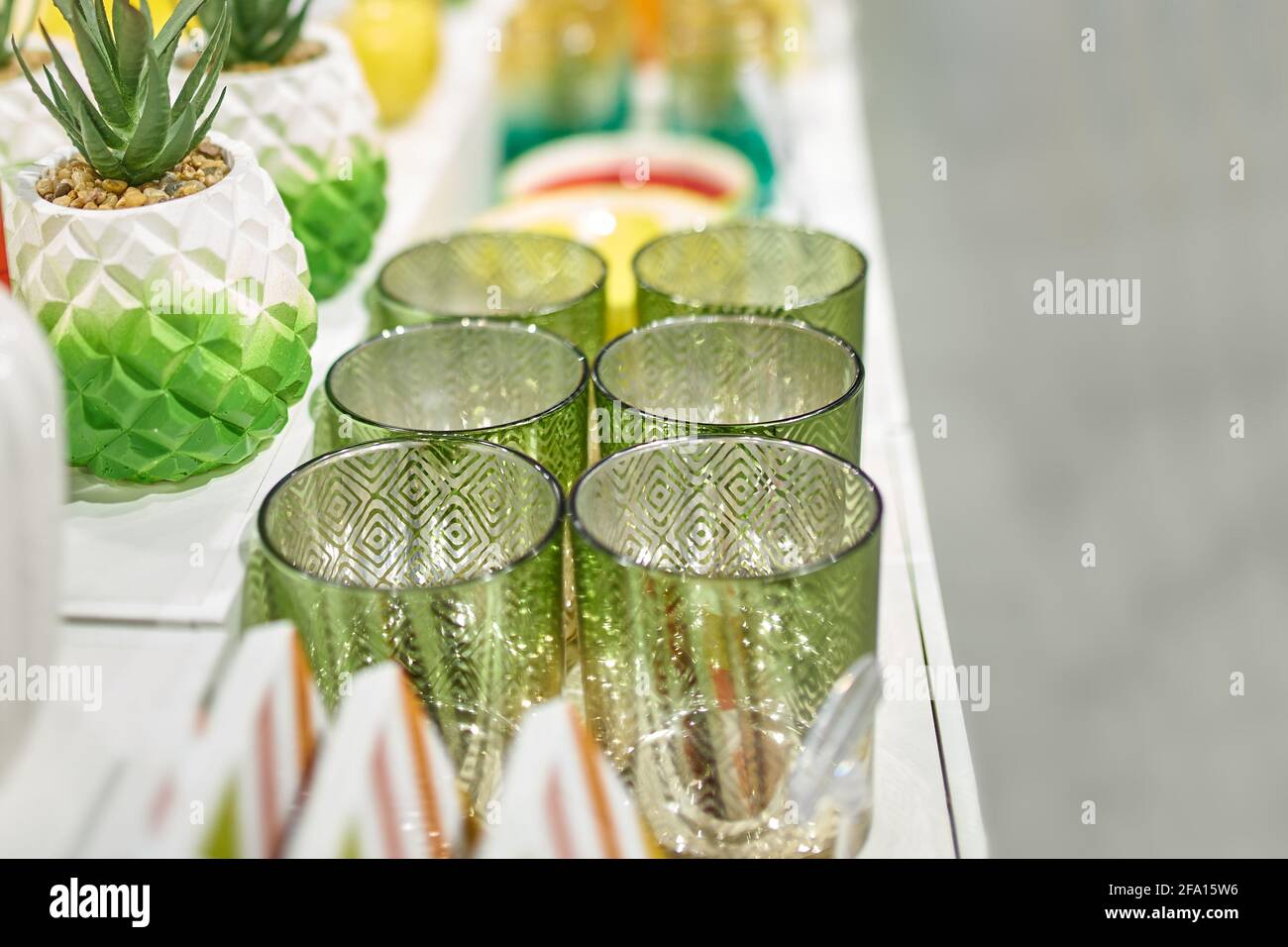 Shop window of home goods store. Patterned green glasses and planters