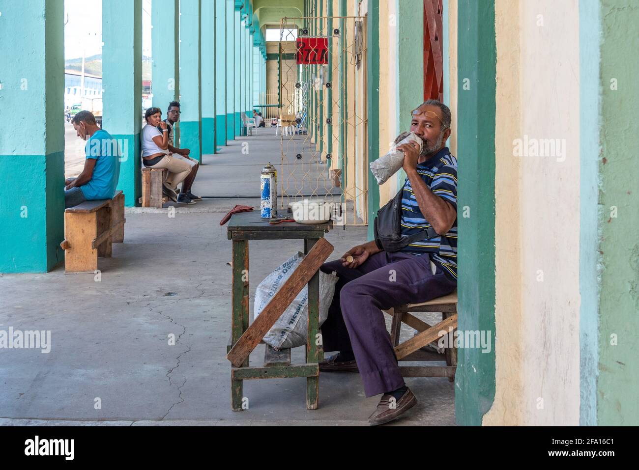 Man drinking water in lighter refiller table, small business, Santiago de Cuba, Cuba Stock Photo