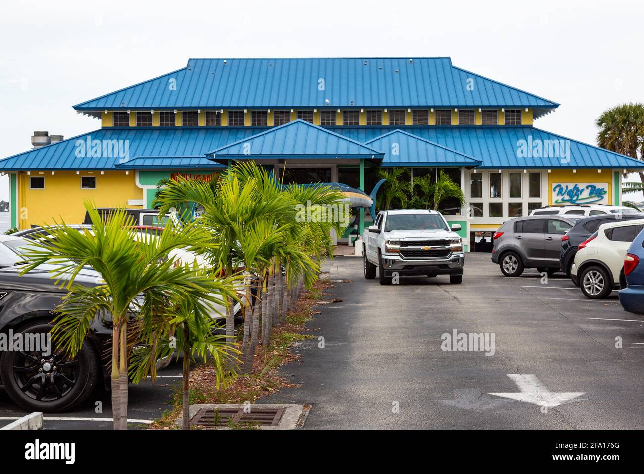 A Chevrolet Silverado pickup truck drives through the parking lot at Mulligan's Beach House Bar and Grill in Stuart, Florida, USA. Stock Photo