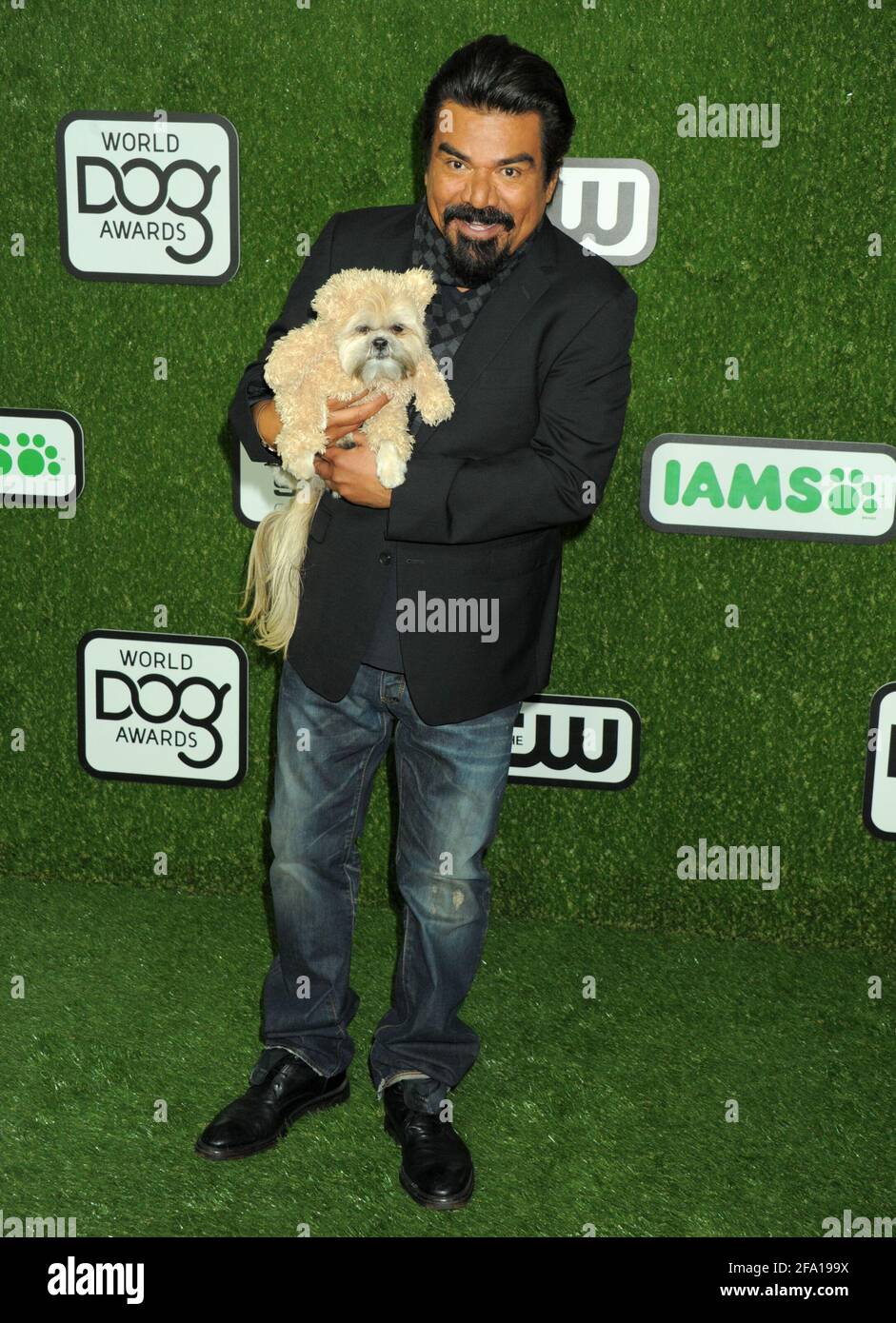 George Lopez, Dog Munchkin on the green carpet during the 2016 World Dog Awards, held at Barker Hanger in Santa Monica, California, Saturday, January 9, 2016.  Photo by Jennifer Graylock-Graylock.com 917-519-7666 Stock Photo
