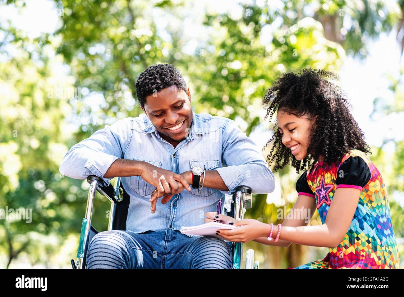 Man in a wheelchair at the park with his daughter Stock Photo - Alamy