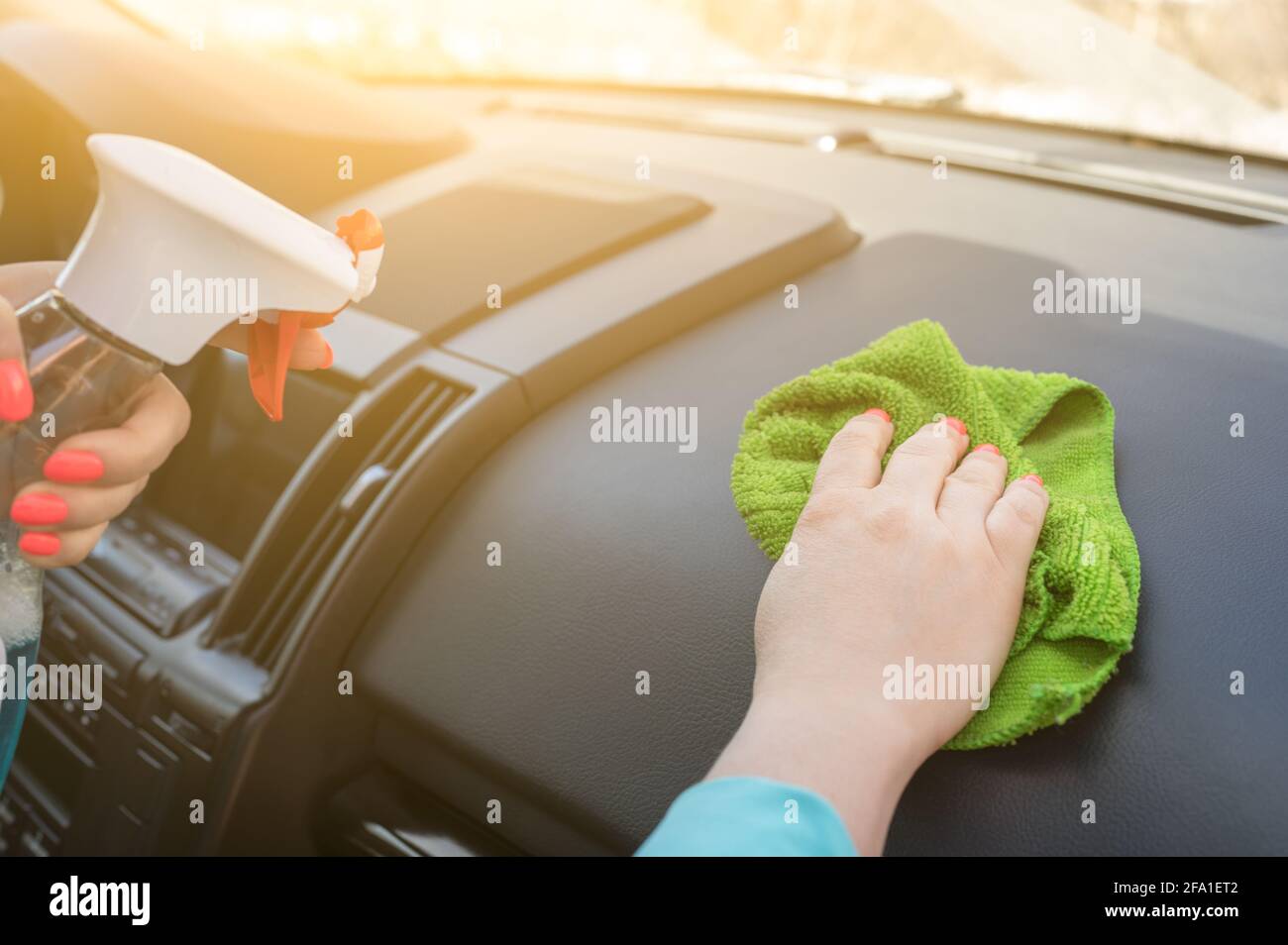Close Up of hands disinfecting the inside of a car with antibacterial