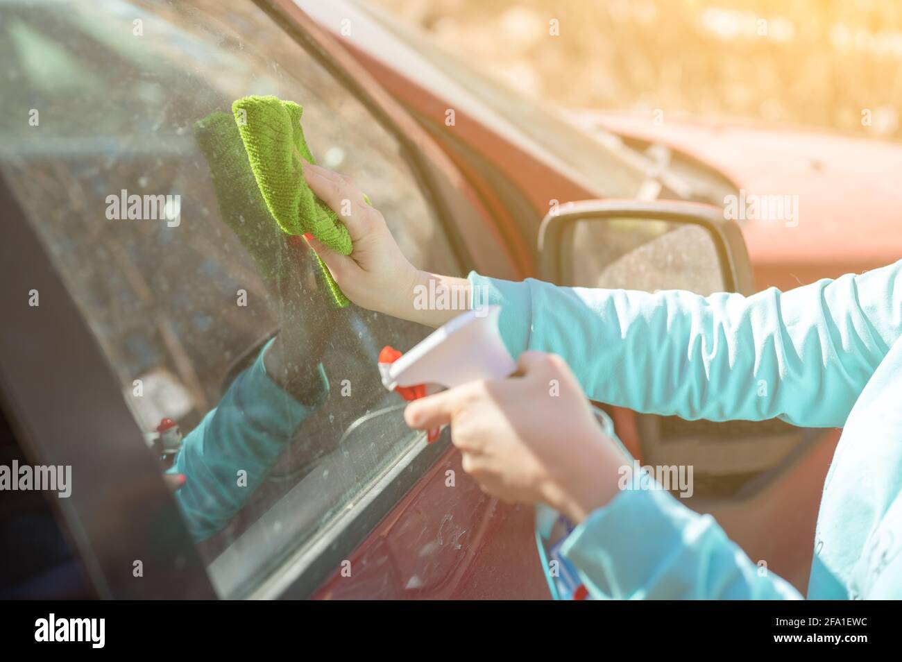 car windows cleaning. female cleaning car windshield with cloth and