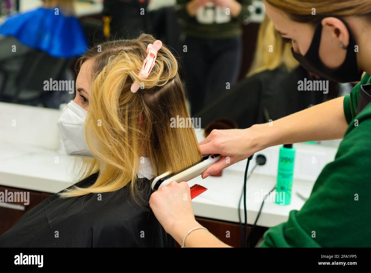 Hair care, hairdresser cuts the cut ends of hair and straightens the