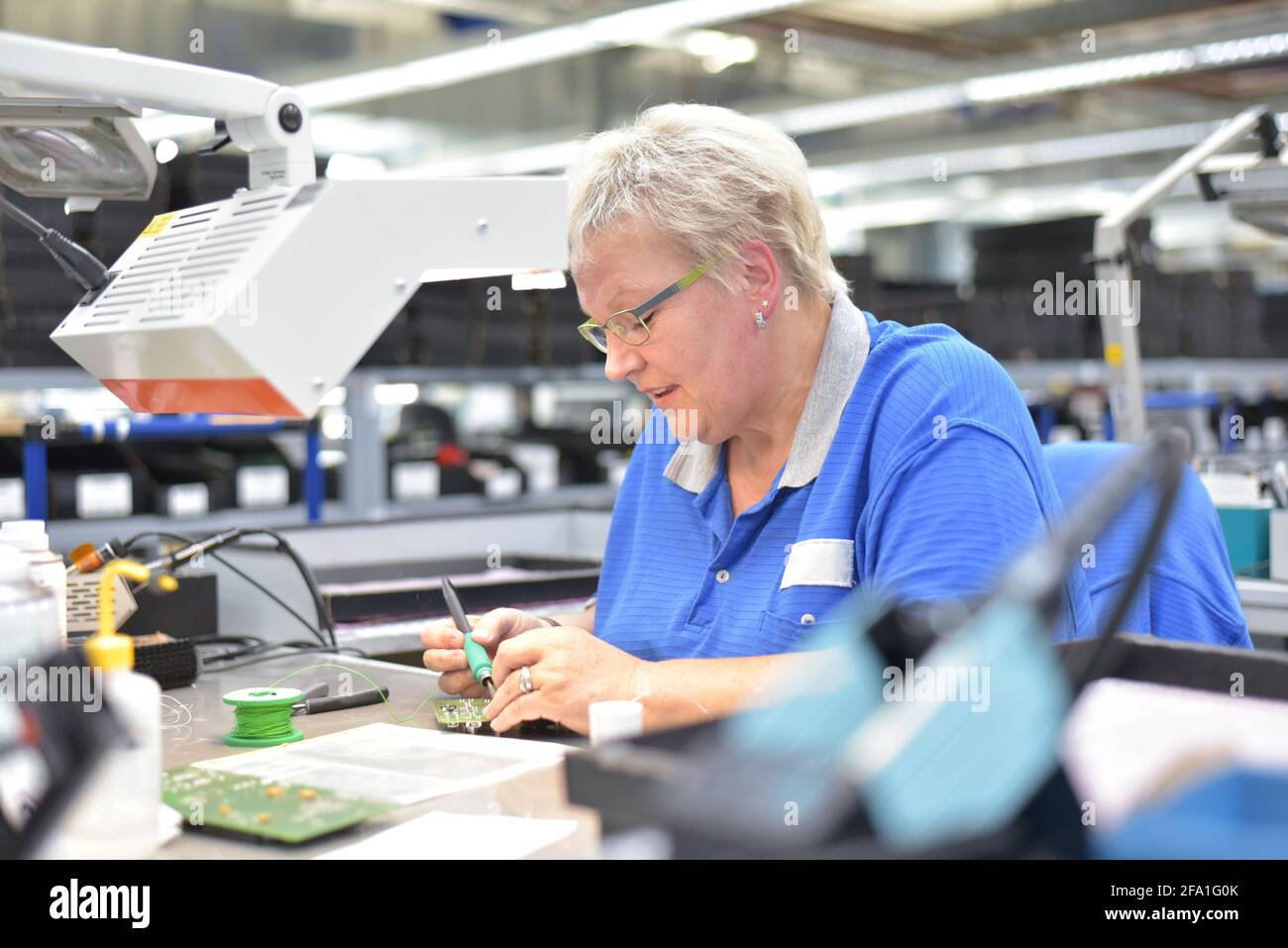 friendly woman working in a microelectronics manufacturing factory ...