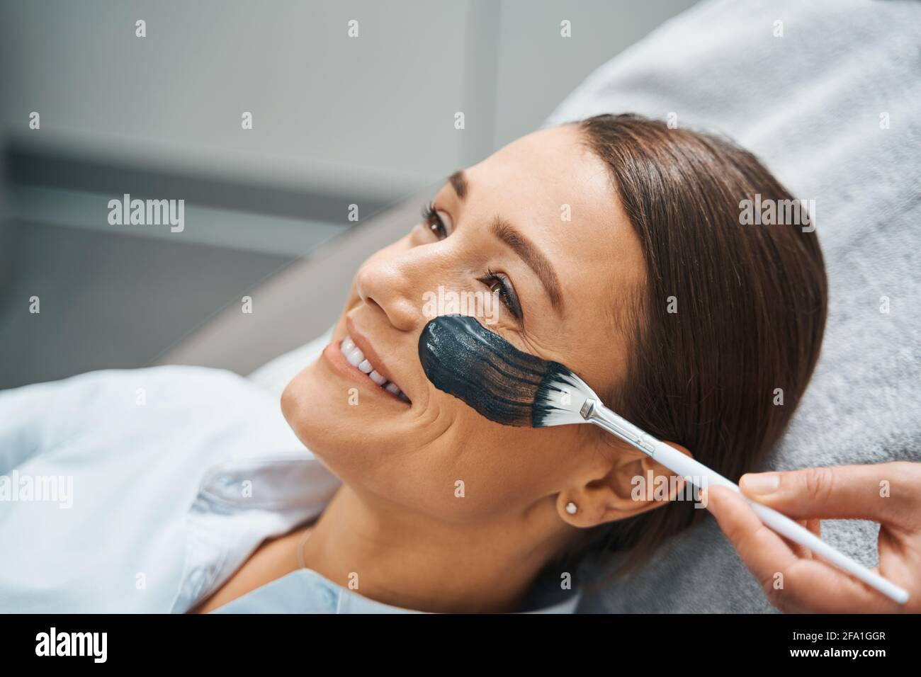 Female patient smiling during a cosmetic procedure Stock Photo