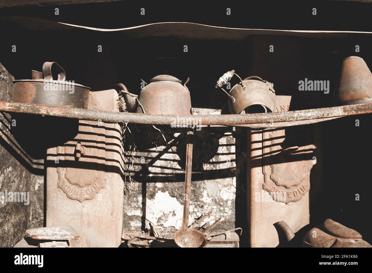 Pots and pans on rack in old rusty stove Stock Photo