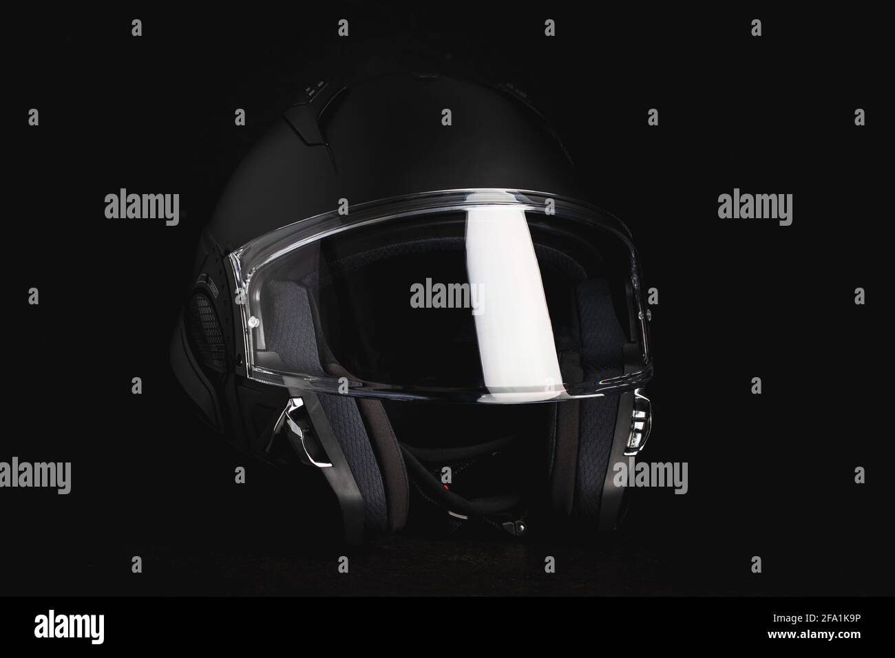 Black modular motorcycle helmet on black background Stock Photo - Alamy