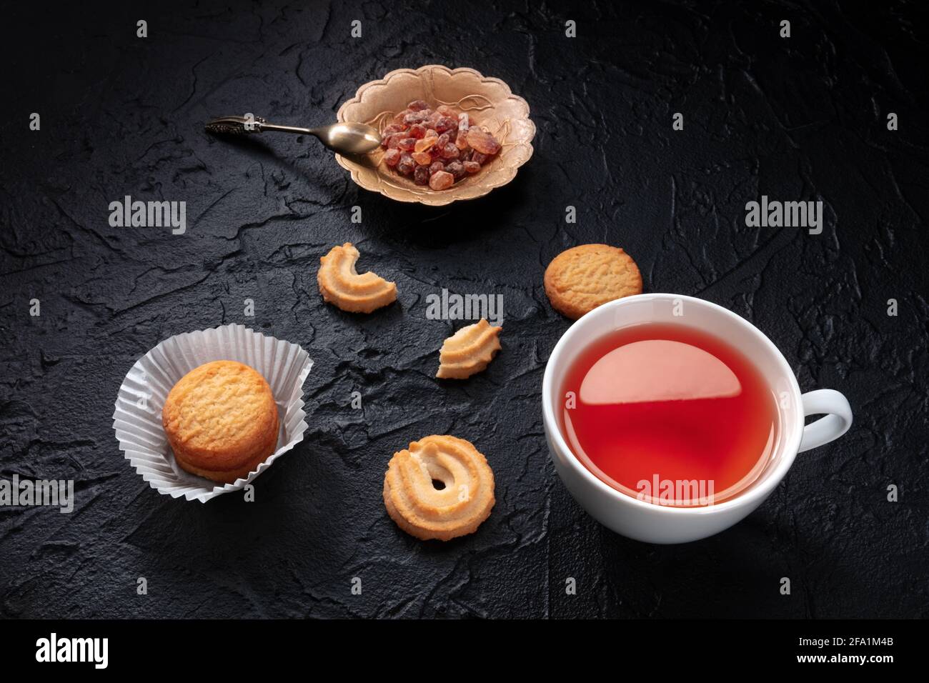Danish butter cookies with a cup of tea on a black slate background Stock Photo