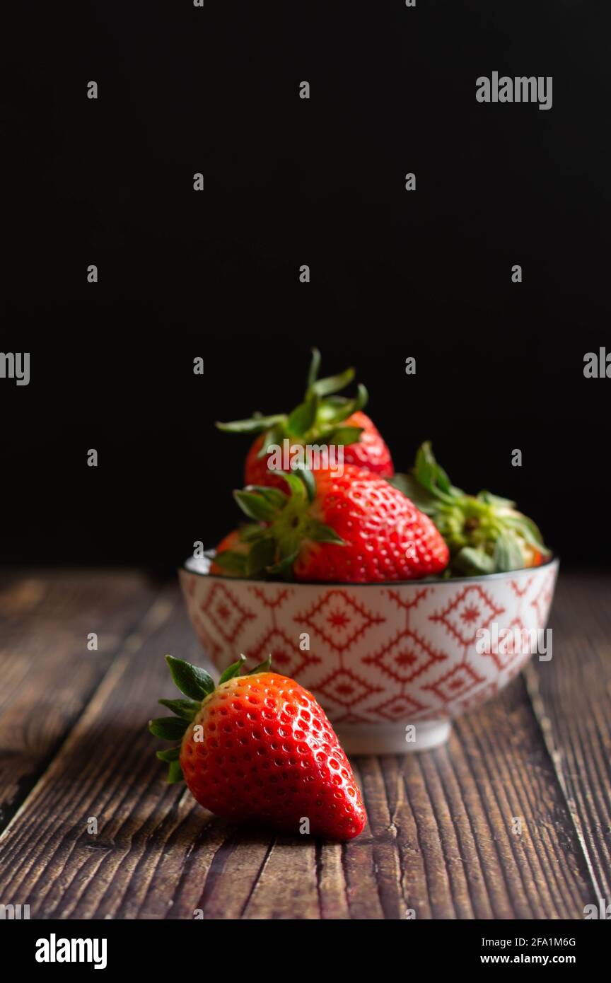 A bowl full of raw and fresh strawberries. Wooden background Stock ...