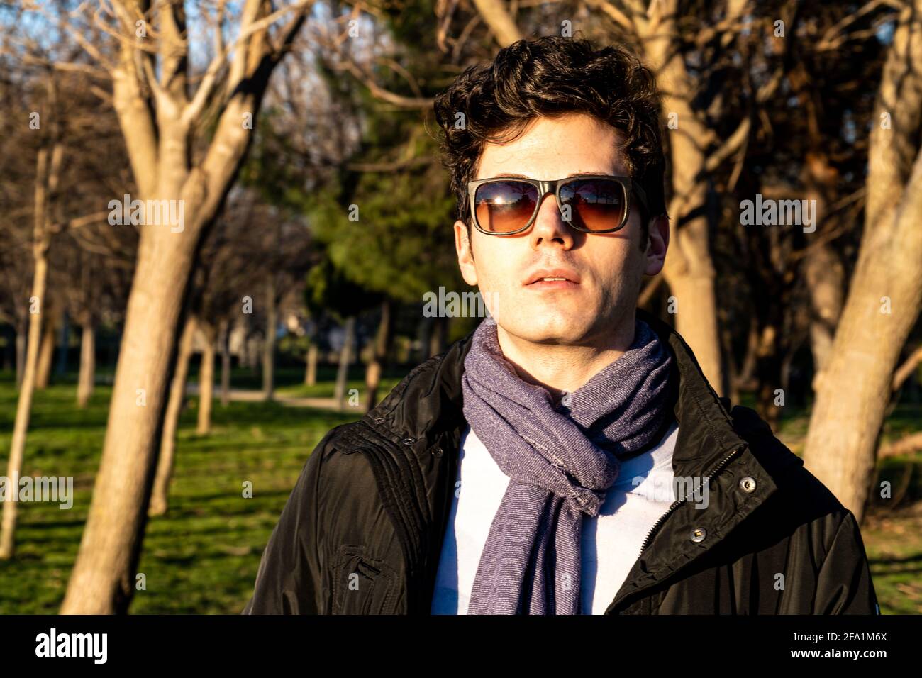 Fashionable Spanish young man looking at a camera against the