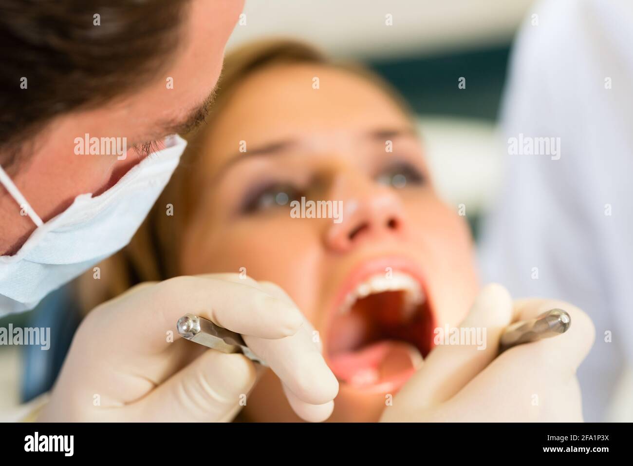Female patient with dentist in a dental treatment, wearing masks and