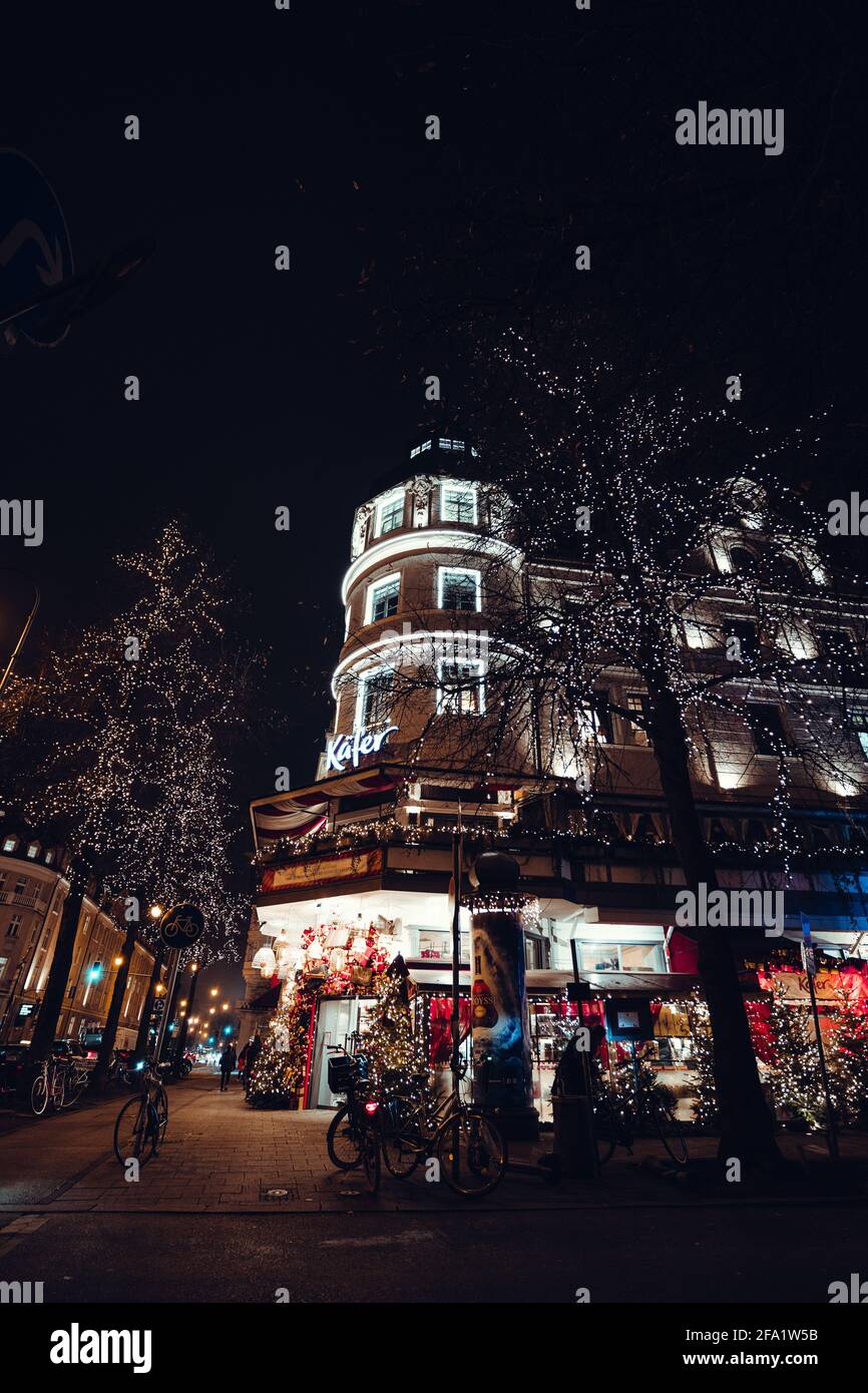 Tower with store look golden and colorful during a Christmas evening. Trees and fairy lights make the scene cozy and glamorous. In Munich, Bavaria. Stock Photo