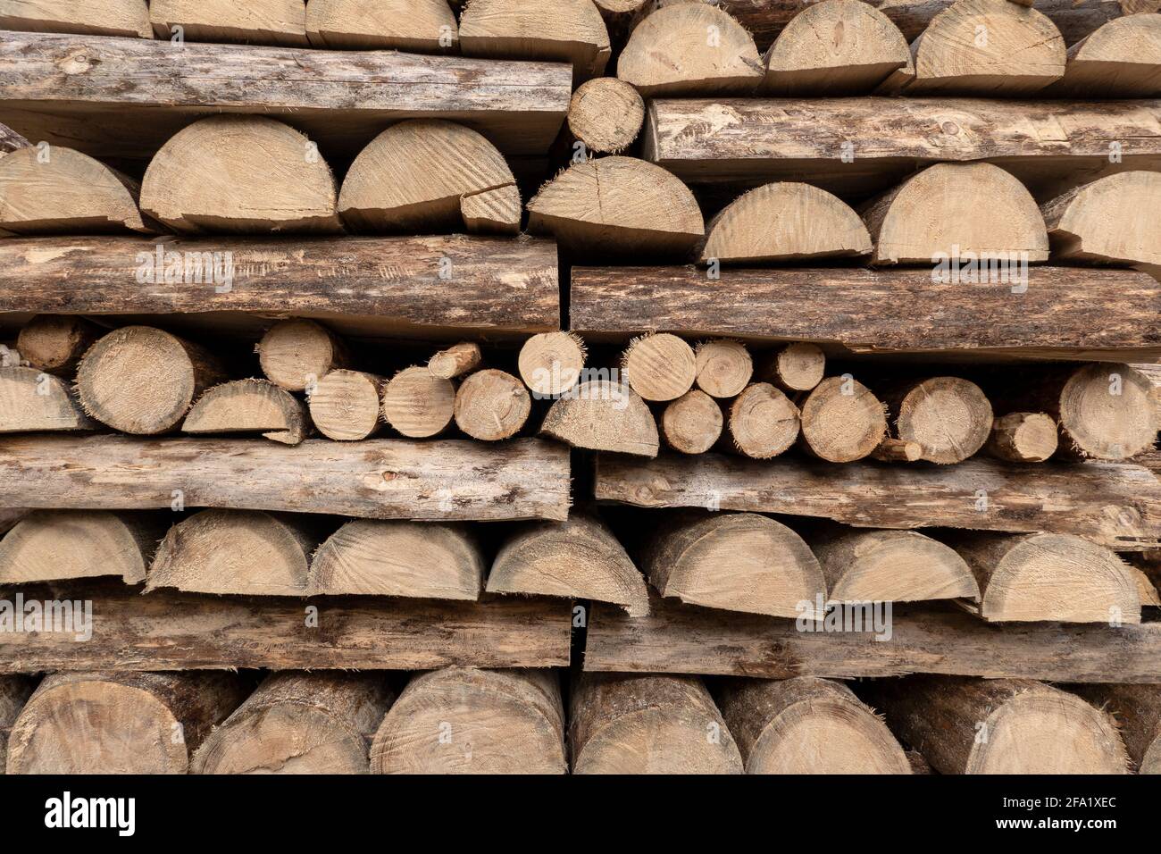 Detail of a woodpile, mostly made of halved tree trunks Stock Photo