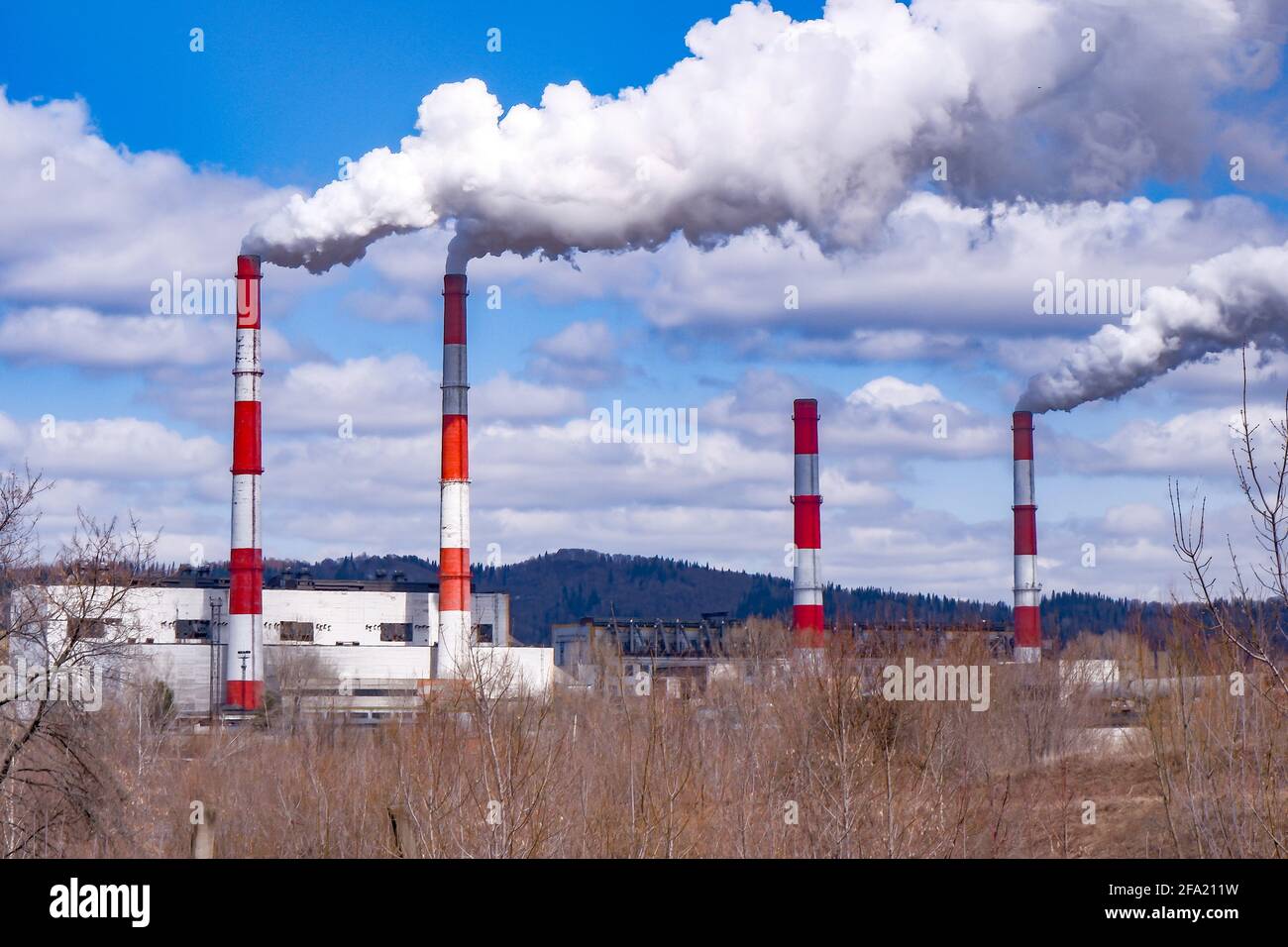 thick smoke comes from the pipes of a small factory.average atmospheric emissions. Stock Photo