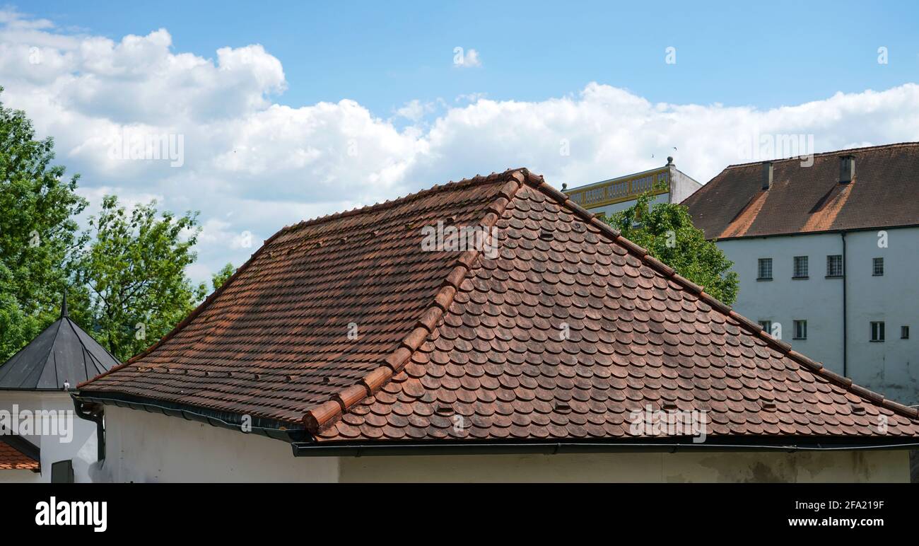 Old building with beautiful roof tiles on a cloudy sky Stock Photo