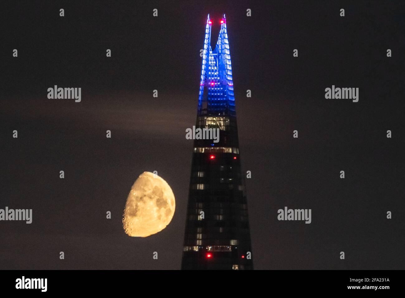 London, UK. 22nd April, 2021. UK Weather: A 75% Waxing Gibbous moon continues to set in the early hours of Thursday moving behind The Shard skyscraper building following a westerly north direction. Credit: Guy Corbishley/Alamy Live News Stock Photo