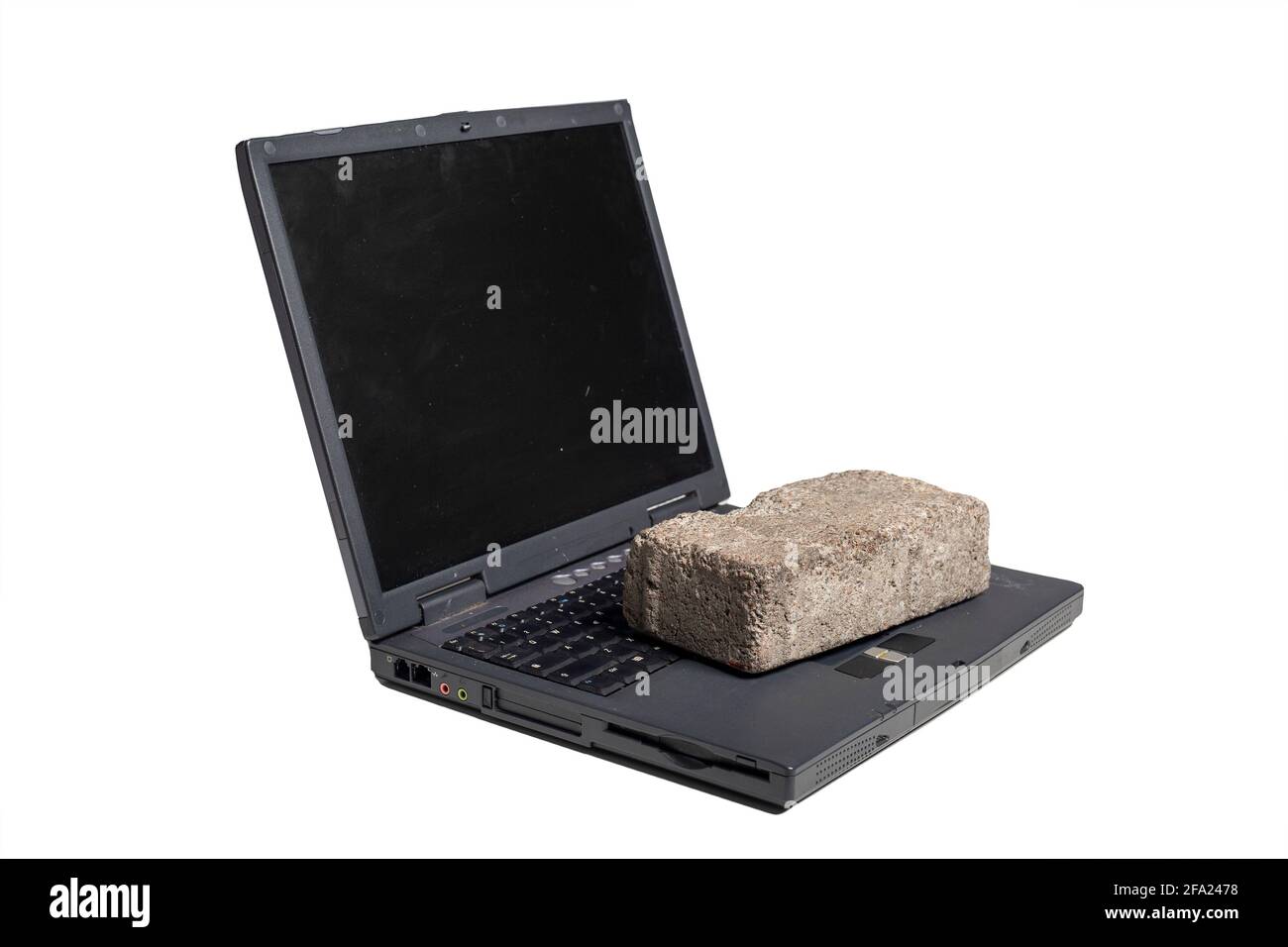 Old broken laptop with brick on us on white background Stock Photo