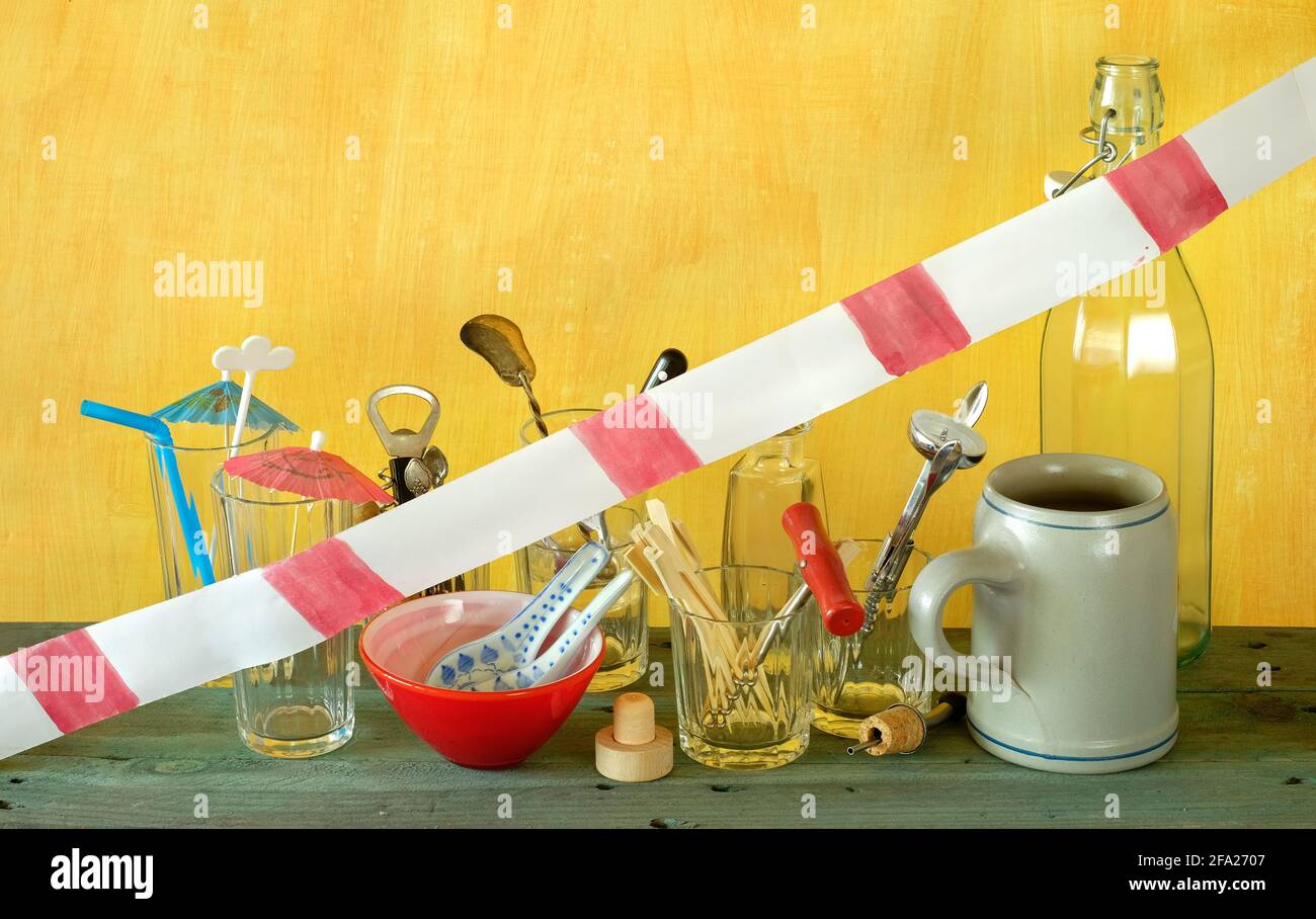 Corona lockdown of bars and pubs, utensils with warning tape on closed bar counter, symbolic Stock Photo