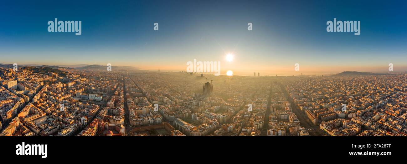 Aerial panorama drone shot of skyline in Barcelona city center in foggy sunrise golden hour in Spain winter Stock Photo