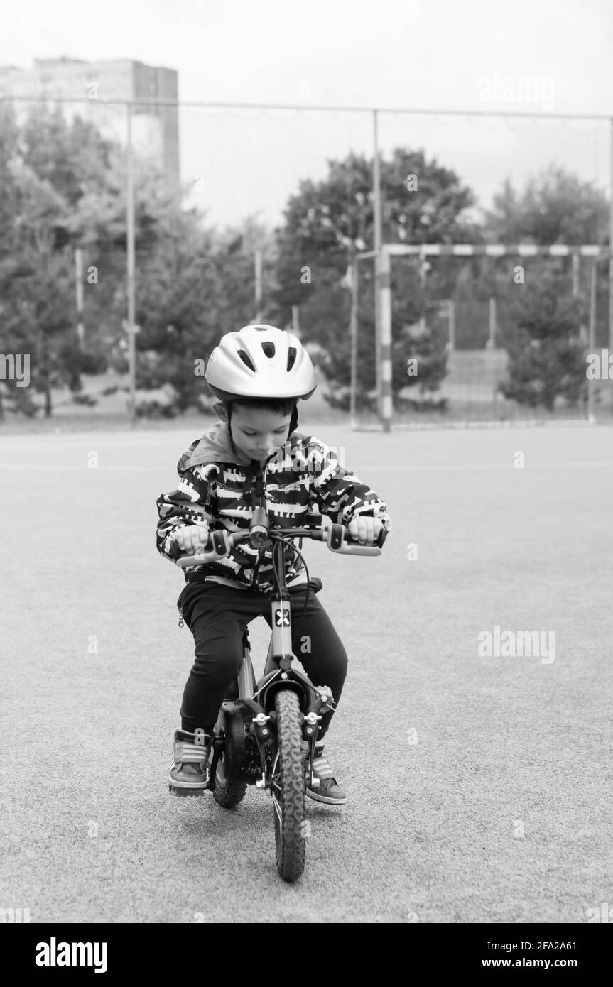 POZNAN, POLAND - Jun 13, 2018: Young Polish Caucasian boy wearing a safety helmet and practicing riding a bike. Stock Photo