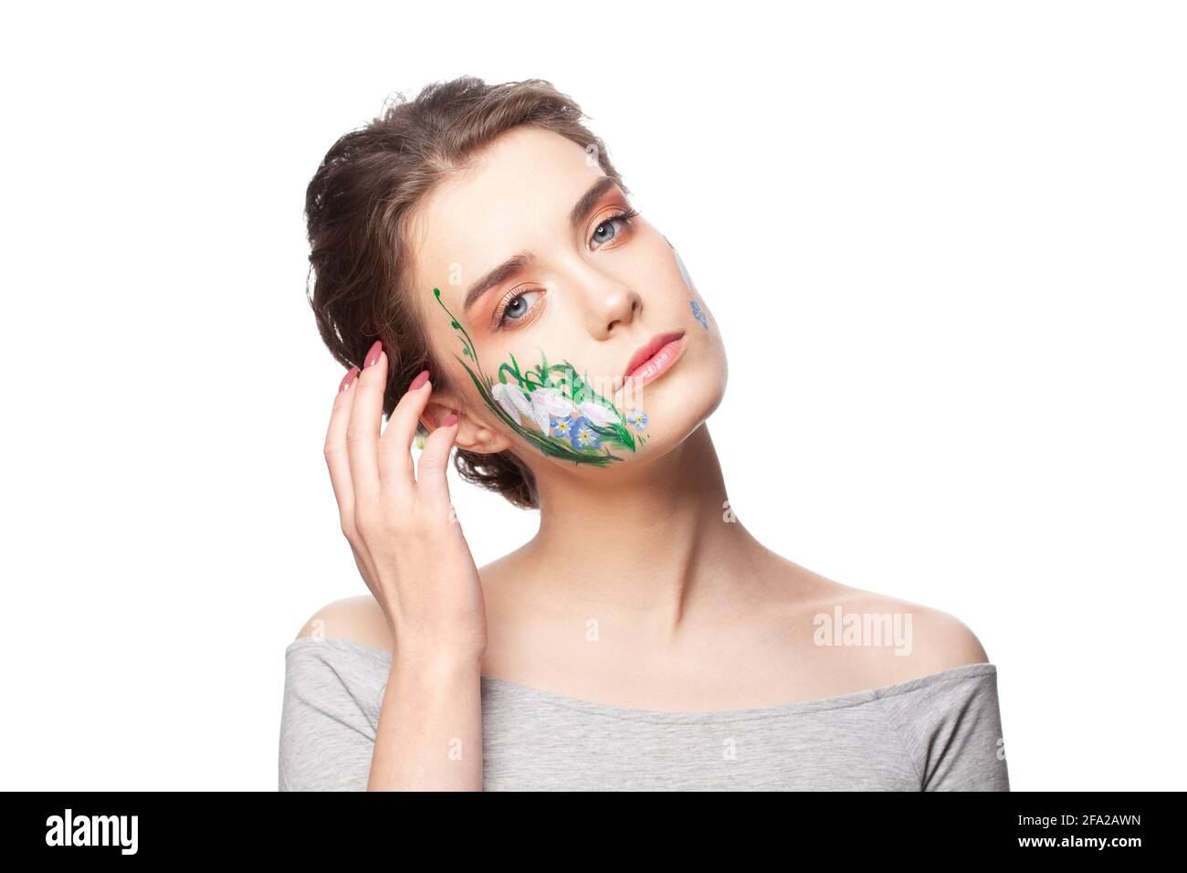 Spring young woman with painted flowers on her face isolated on white background Stock Photo