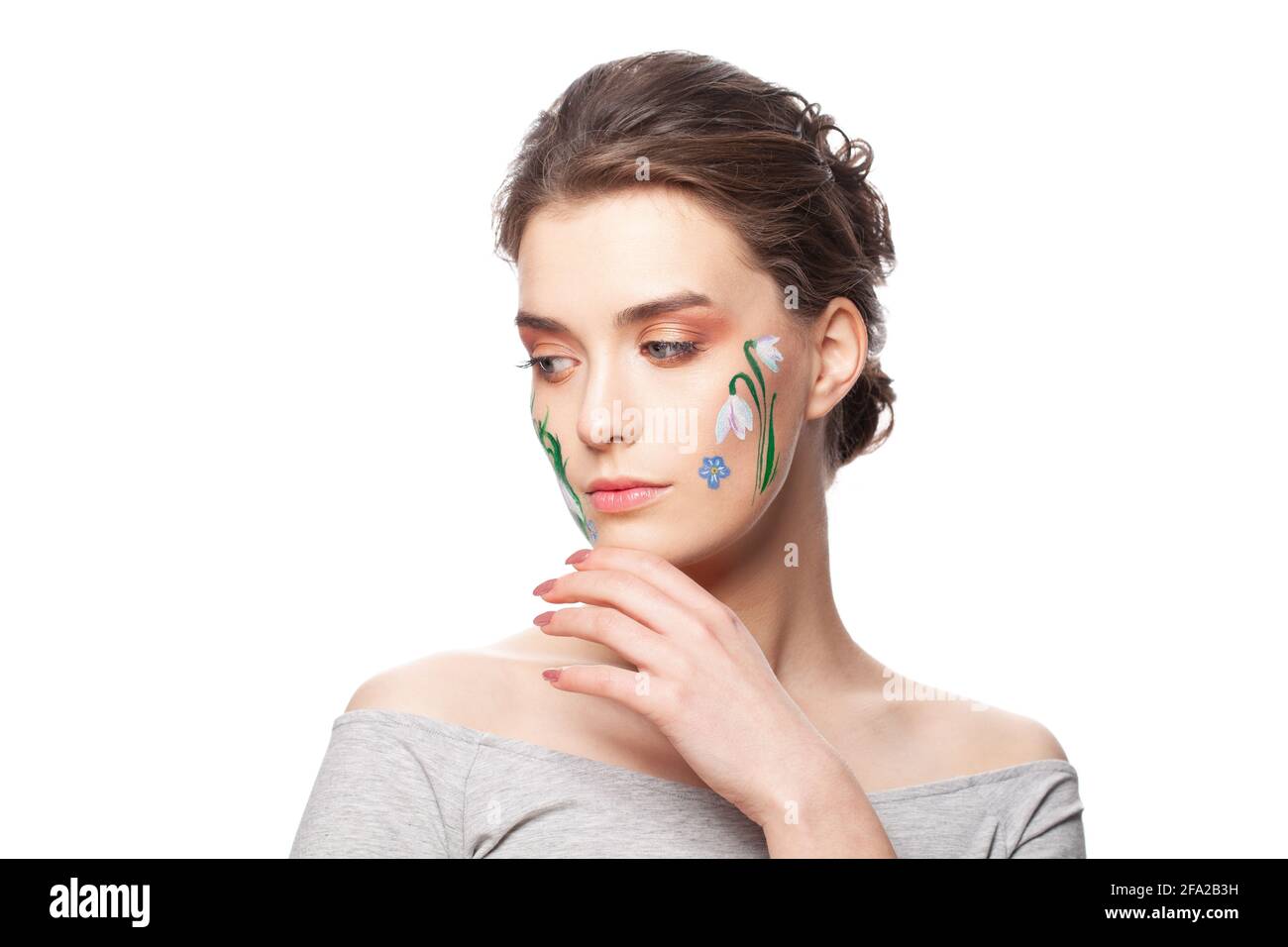 Lovely young woman with painted flowers on her face isolated on white background Stock Photo