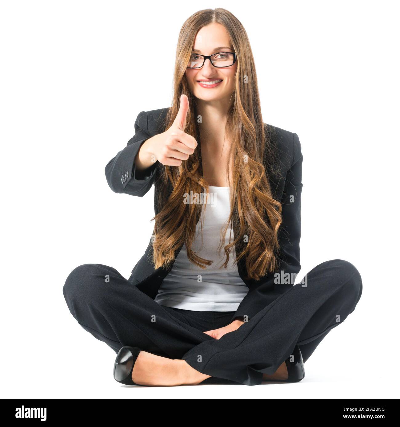 Young woman in front of white background, sitting on the floor, maybe she is a businesswoman or lawyer Stock Photo