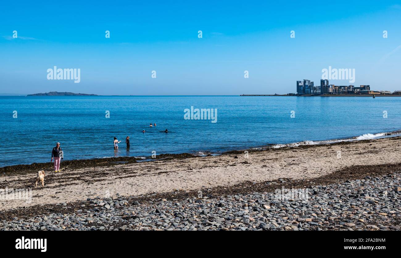 Edinburgh, Scotland, United Kingdom. 22nd April, 2021. UK Weather: Spring sunshine for wild swimmers. Wardie Bay at Granton with a view to Platinum Point modern high rise apartment development has become a popular place for wild swimmers during the pandemic Stock Photo