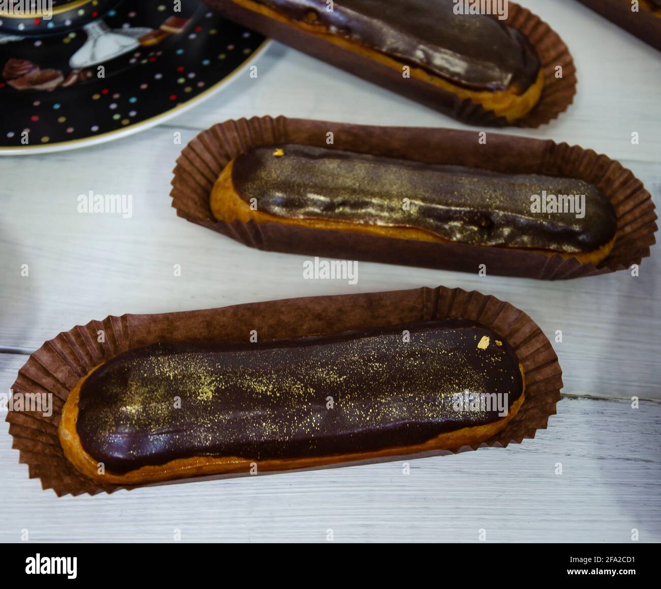 Gorgeous extra chocolate eclairs with gilded glaze Stock Photo