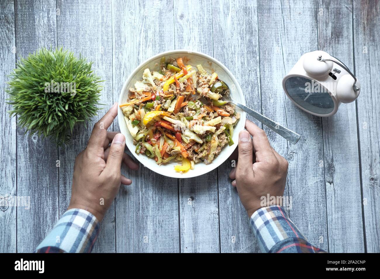 young man in casual dress eating fresh salad , healthy food concept  Stock Photo