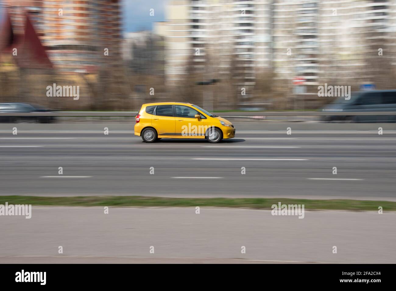 Ukraine, Kyiv - 6 April 2021: Yellow Honda Jazz car moving on the street. Editorial Stock Photo