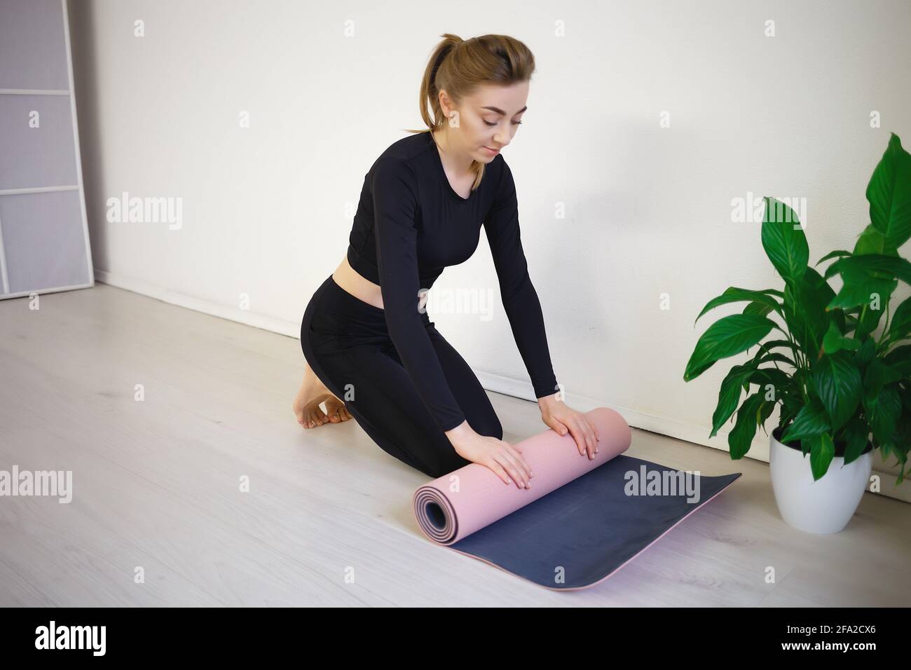 woman unfold yoga mat preparing for practice. Stock Photo