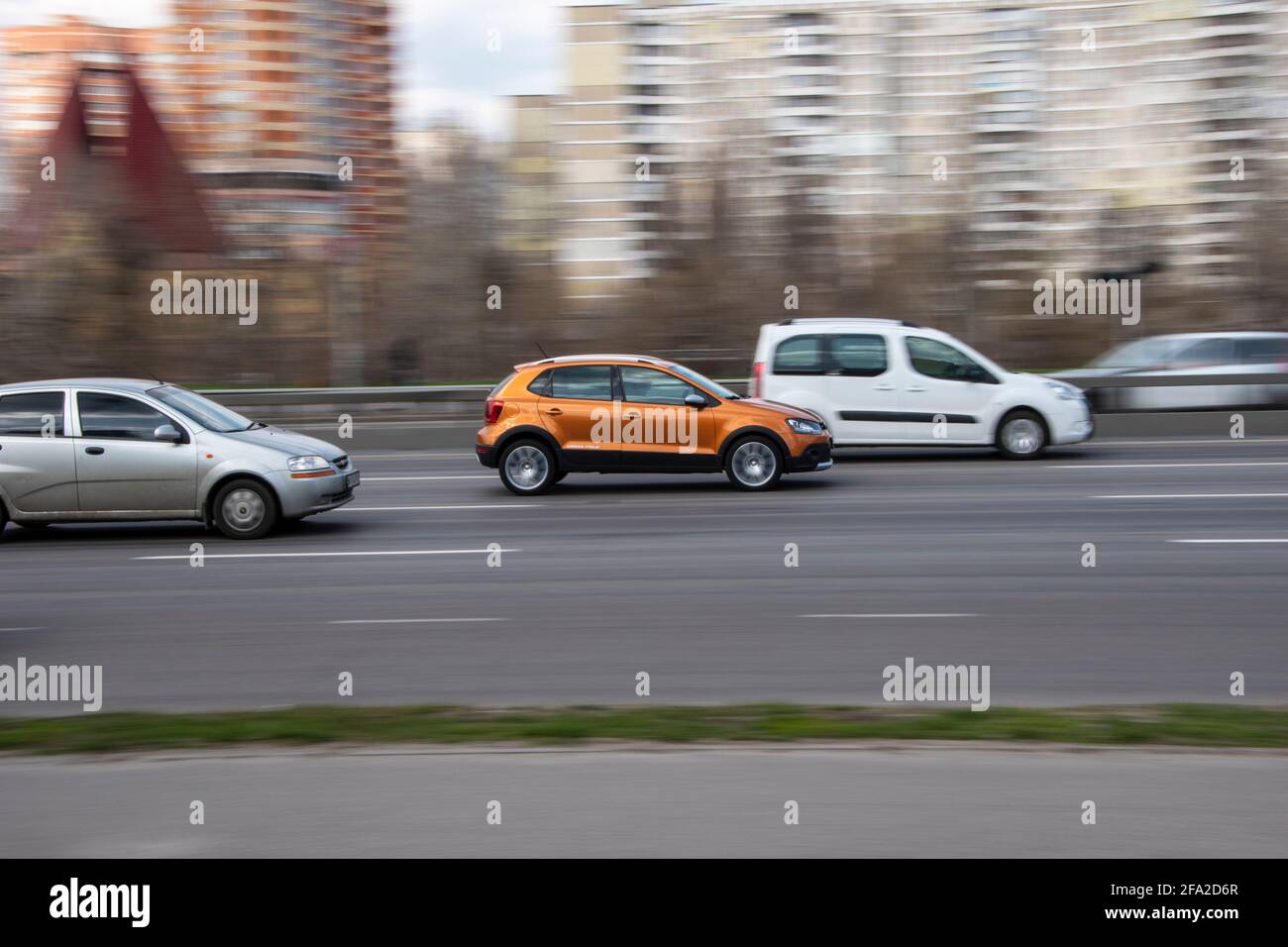 Ukraine, Kyiv - 6 April 2021: Orange Volkswagen Other car moving on the street. Editorial Stock Photo
