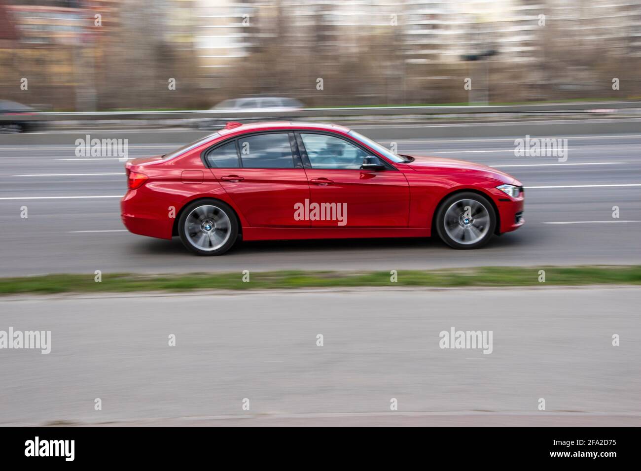 Ukraine, Kyiv - 6 April 2021: Red BMW 3 series car moving on the street. Editorial Stock Photo