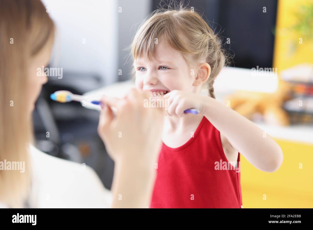 Dentist shows girl how to brush her teeth properly Stock Photo