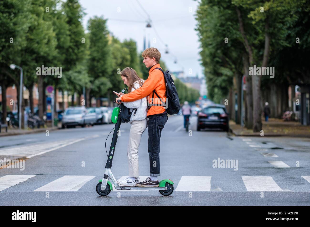 Copenhagen, Denmark - June 7, 2019 Lime electric scooter. Two teenagers  ride a scooter through a crosswalk in Copenhagen Stock Photo - Alamy