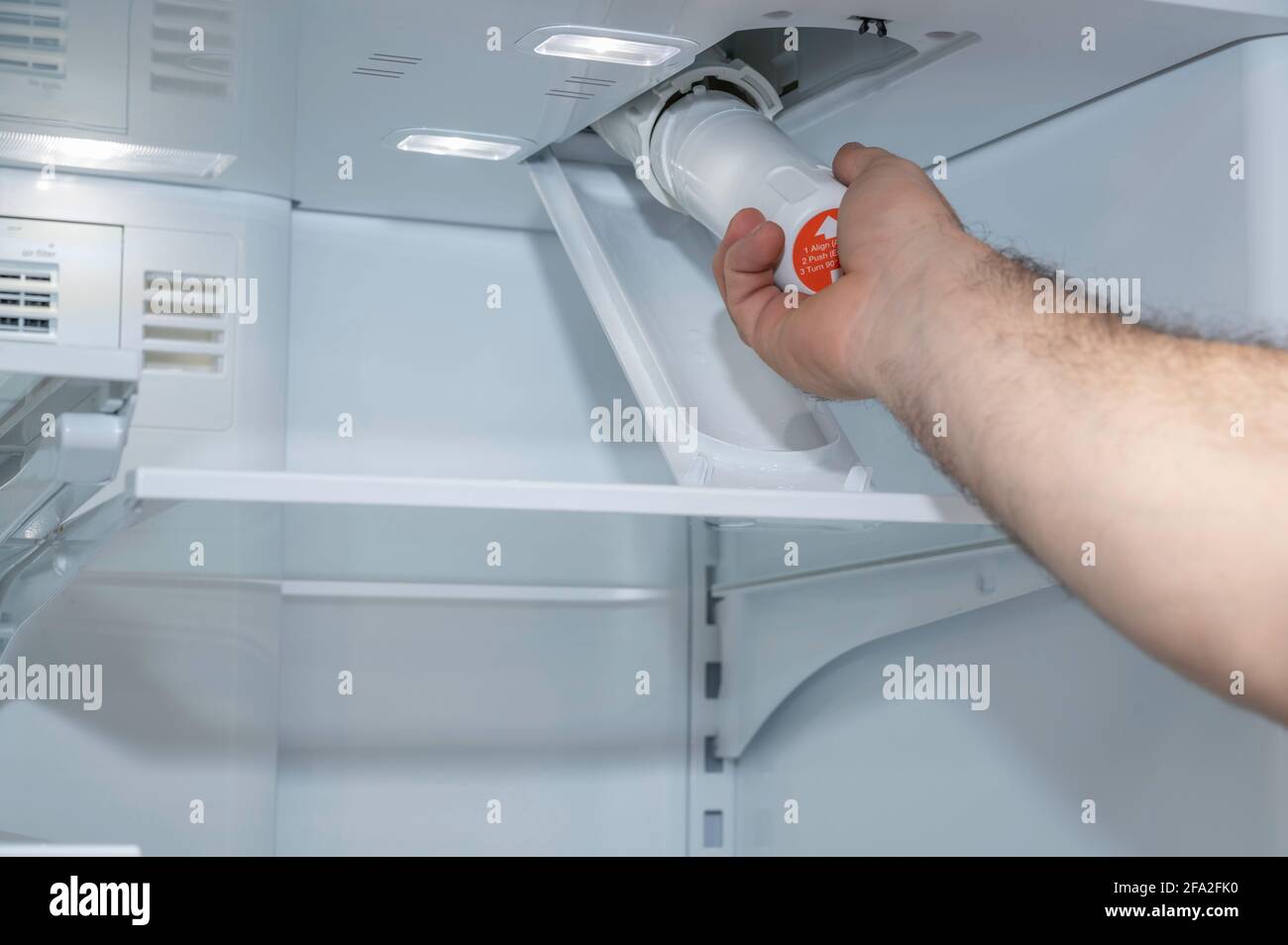 Installing a fridge water filter on a modern appliance Stock Photo Alamy