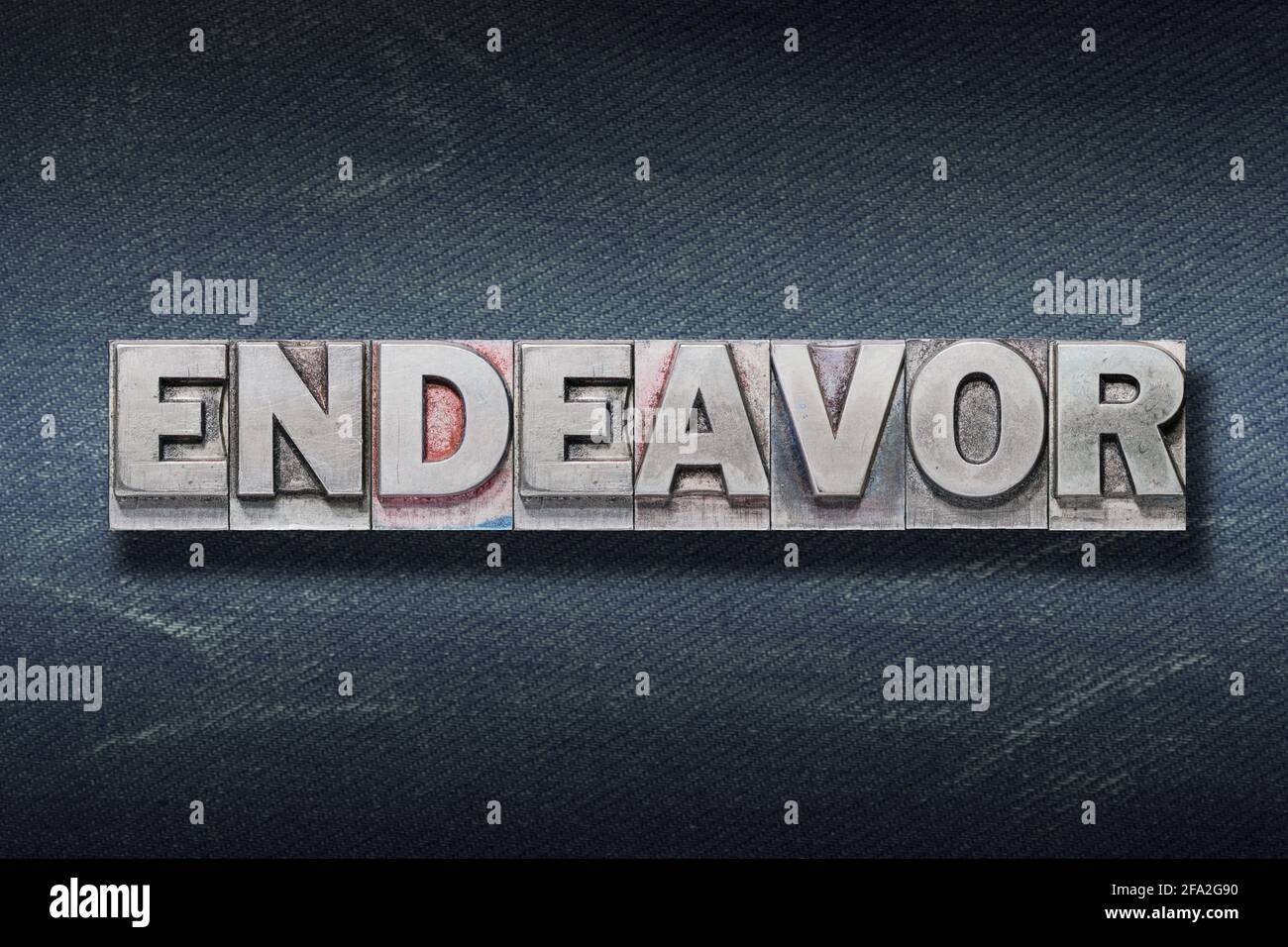 endeavor word made from metallic letterpress on dark jeans background Stock Photo