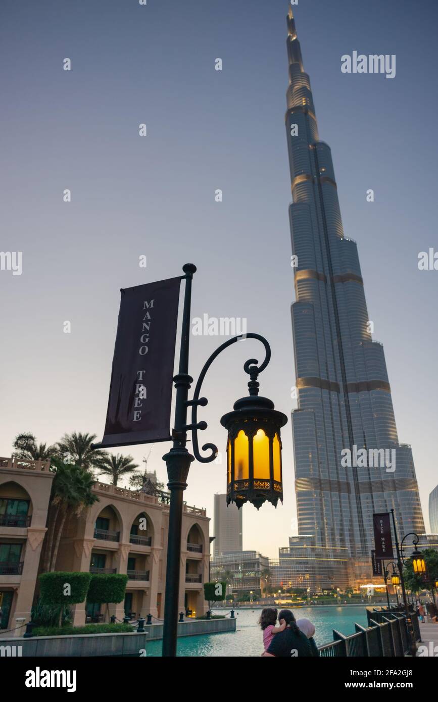 Dubai, UAE - May 31, 2013. Mango Tree Thai Bistro Restaurant ad located at the street lamp next to The Dubai Mall and Burj Khalifa skyscraper in Dubai Stock Photo