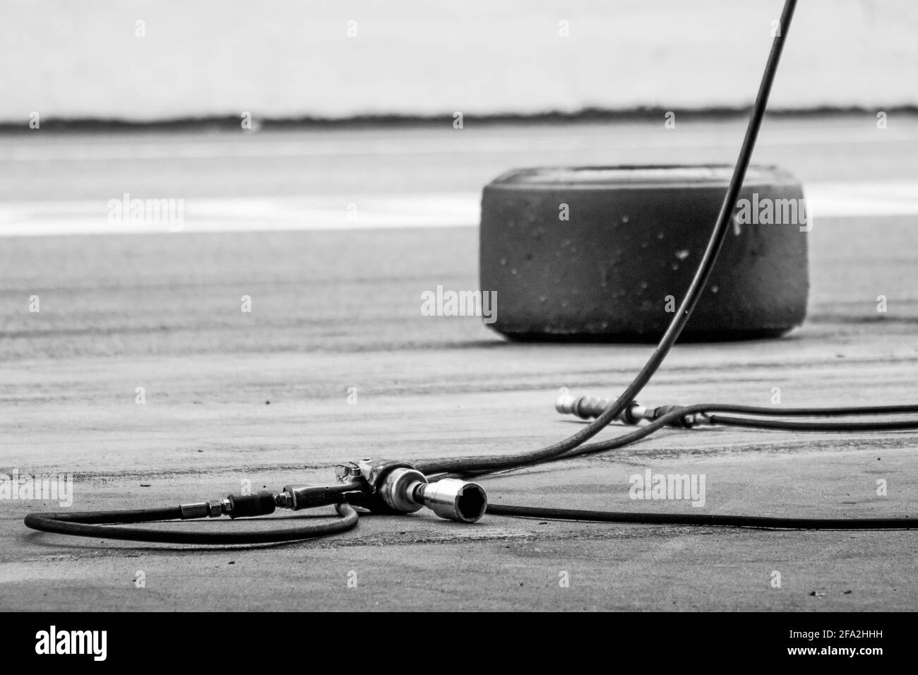 Grayscale of a wheel gun for the motor racing championship on the road Stock Photo
