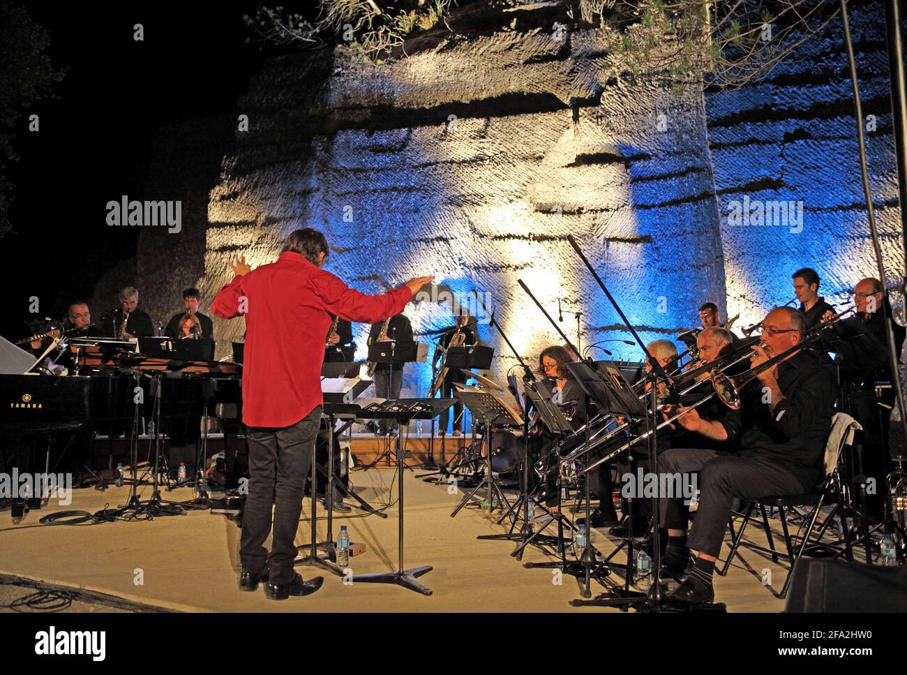 A conductor and Jazz orchestra on stage in the open air Carrieres du Bon Temps, Junas Quarries, Gard, France Stock Photo