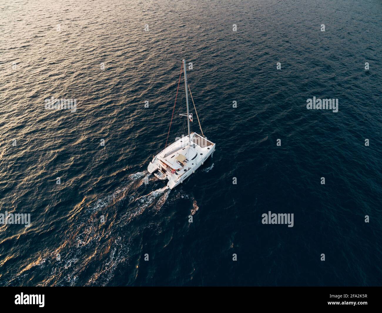 White sailing catamaran yacht sails in the blue sea Stock Photo - Alamy