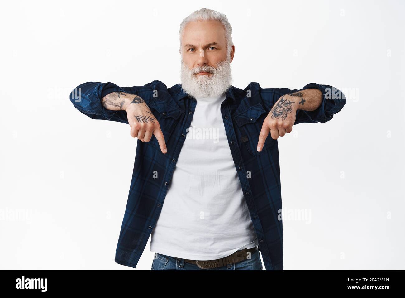 Handsome bearded grandfather, cool grandpa with tattoos pointing fingers  down, showing promo deal, offer promotion bellow, standing in stylish  modern Stock Photo - Alamy, image size:1300x956