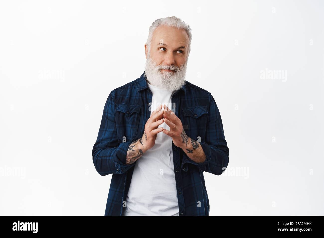 Thoughtful hipster old guy steeple fingers, looking right at thinking, making evil genius plan, pondering something, standing against white background Stock Photo
