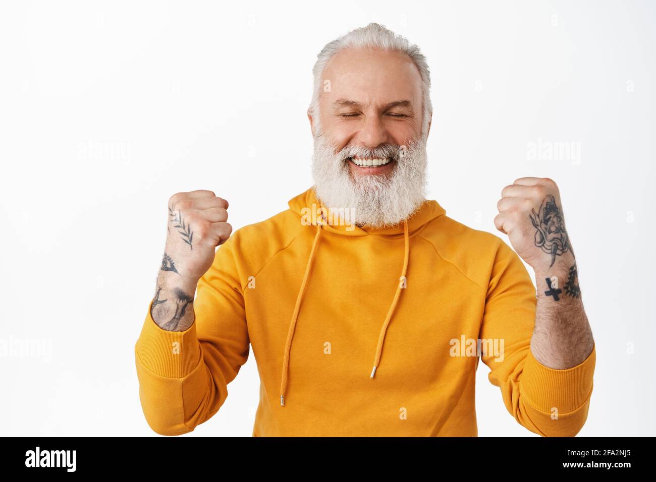 Yes success. Smiling happy senior man triumphing, celebrating win and victory, make fist pump with rejoice, looking cheerful after winning money, got Stock Photo