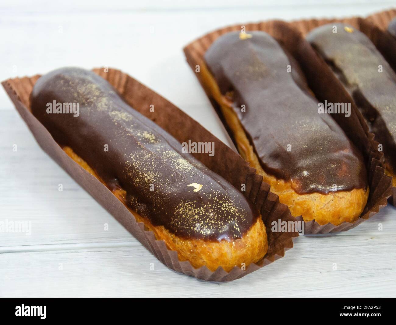 Gorgeous extra chocolate eclairs with gilded glaze Stock Photo
