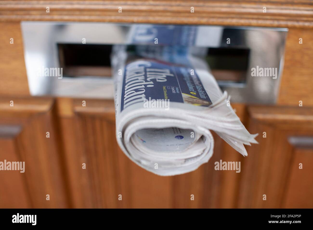 Daily newspaper in front door letterbox  The Guardian, British Daily newspaper owned by Guardian Media Group plc GMG The group is wholly owned by the Scott Trust Limited Stock Photo