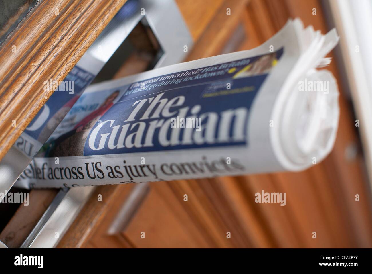 Daily newspaper in front door letterbox  The Guardian, British Daily newspaper owned by Guardian Media Group plc GMG The group is wholly owned by the Scott Trust Limited Stock Photo